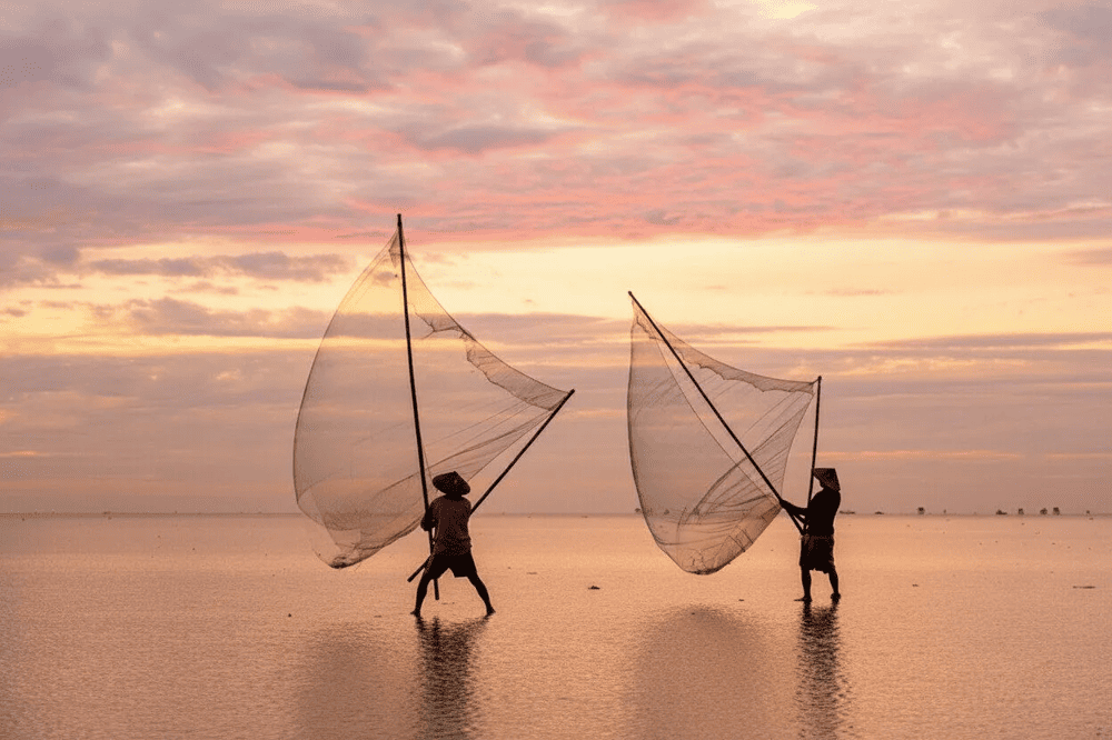 Local fishermen pull in nets at dawn, capturing the authentic rhythm of life at Bai Xep village center